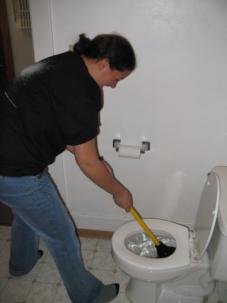 Denver plumbing customer demonstrates plunger usage